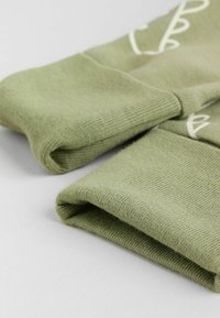 Poignets de pull en tricot verts avec une texture côtelée, présentant un motif décoratif simple en beige clair tissé dans le tissu.