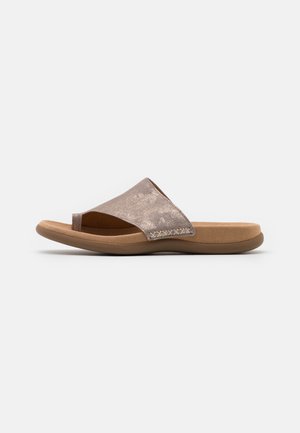 Brun sandal med åben tå med en bred metalrem og en polstret sål, vist i profil på en neutral baggrund.