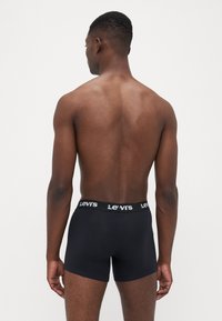 Boxer briefs neri realizzati in materiale liscio, con un elastico con marchio e scritte bianche, design a gamba corta e silhouette aderente.