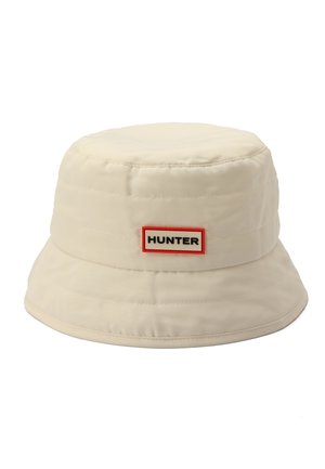 Beige bollenhoed met brede rand en rechthoekig rood omrande label met de tekst "HUNTER" aan de voorkant.