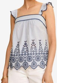 Blå och vit randig tanktop med volangband, intrikata marinblå blommor broderade längs fållen och lätt tygkänsla.