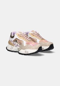 Zapatillas deportivas voluminosas con paneles en rosa, dorado, beige y blanco, patrones texturizados y suelas negras rugosas sobre un fondo blanco.