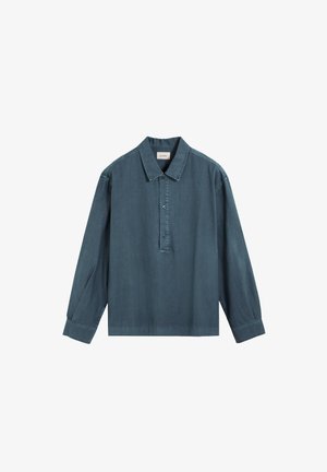 Camisa de mezclilla azul de manga larga con cuello y tapeta con tres botones, mostrada sobre un fondo blanco liso.