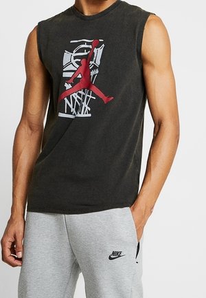 Maglietta senza maniche Nike di colore grigio scuro con logo Jordan rosso e grafica bianca di un canestro da basket. Tessuto in cotone, vestibilità rilassata.