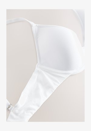 Valge rinnahoidja, millel on sile kangas, vormitud tissid, reguleeritavad rihmad ja haakeseadisega kinnis. Iseloomustab õmblusteta disain, mis tagab puhta välimuse.