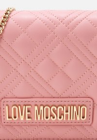 Pink quilted leather handbag with gold chain strap and gold "LOVE MOSCHINO" logo plaque on front.