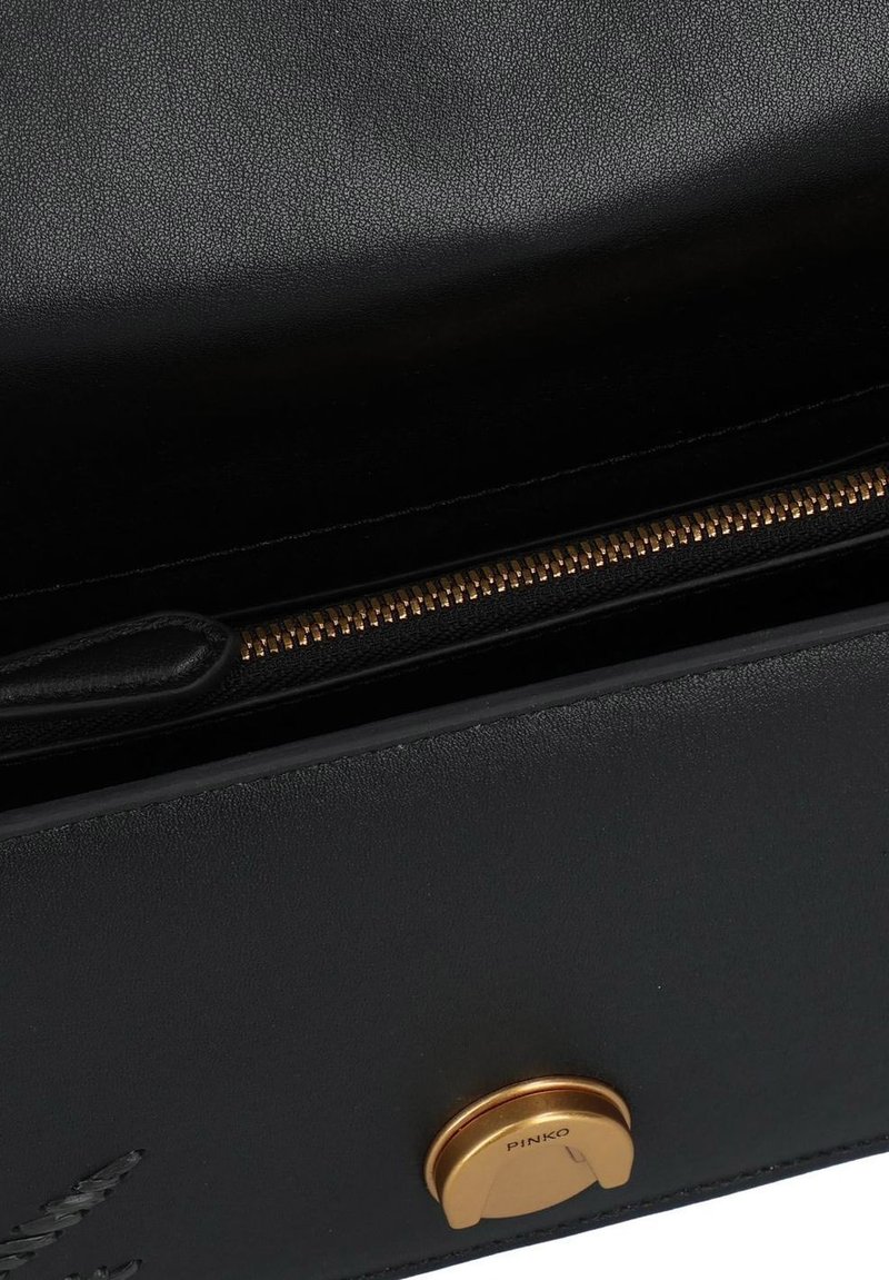 Bolso de cuero negro con un acento de herrajes dorados y un acabado texturizado, con un cierre superior de cremallera y un detalle de marca sutil.