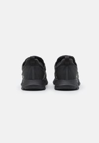 Black athletic shoes with a streamlined design, featuring a textured upper and padded collar. The sole is textured for grip.