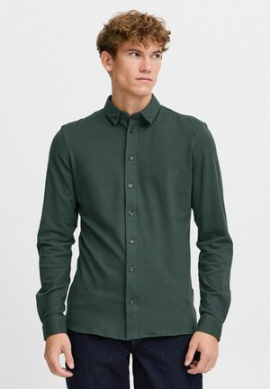 Dark green long-sleeve shirt with a button-down collar, made from a smooth material, featuring a front button closure and buttoned cuffs.