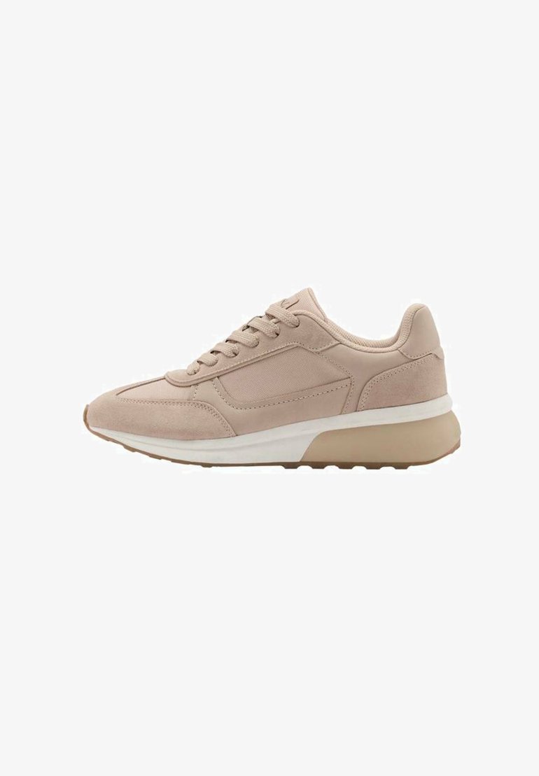 Sneaker beige chiaro con una combinazione di texture lisce e scamosciate, allacciatura tradizionale e suola in gomma bianca e tan. Presenta un design a punta arrotondata.