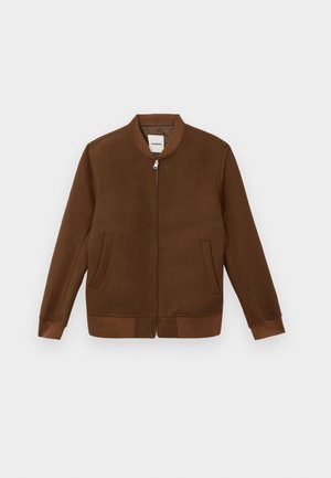 Giacca bomber marrone con scollatura rotonda, zip frontale, due tasche laterali, polsini e orlo a costine. Tessuto liscio con una sottile texture.