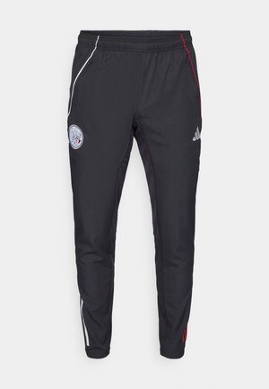 Pantalones deportivos negros con corte ajustado. Presentan franjas laterales en blanco y rojo, un cinturón elástico y un logo bordado en el muslo superior.
