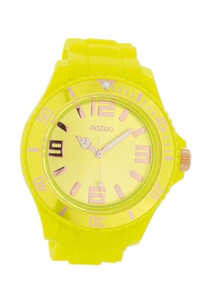 Montre en silicone jaune vif avec un cadran rond, des accents en or rose, des chiffres surdimensionnés et un bracelet flexible. Conception résistant à l'eau.