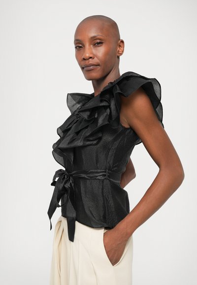 Must mustrikkidega top tekstureeritud viimistlusega ja vöödiga talje. Omab suure mõõtmega volanite kaunistusi õlgadel ja kõige peenemat figuuri.