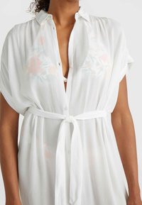 White button-up dress with a tie belt, featuring a subtle floral pattern, lightweight texture, and short sleeves.