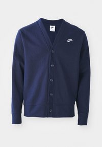 Marinblå Nike cardigan med lång ärm, knappstängning fram, V-hals och vitt broderat Nike-logotyp på vänster bröst.