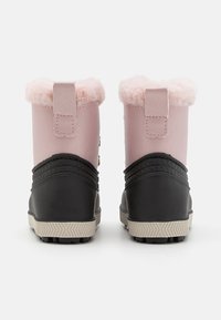 Rosa og sorte ankelstøvler med faux pelsdetaljer, gummibunn, teksturert design og to gullknapper på hver side.