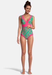 Maillot de bain une pièce en vert et rose. Présente un motif géométrique, un décolleté en V et des bretelles larges. Fabriqué en tissu élastique pour le confort.