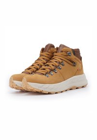 Tan suede hiking boots with brown leather accents, metal hooks, and brown laces. Chunky white midsole with a textured sole for grip.