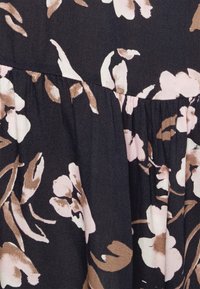 Tecido preto com um padrão floral em tons de rosa e bege, apresentando babados para textura e dimensão.