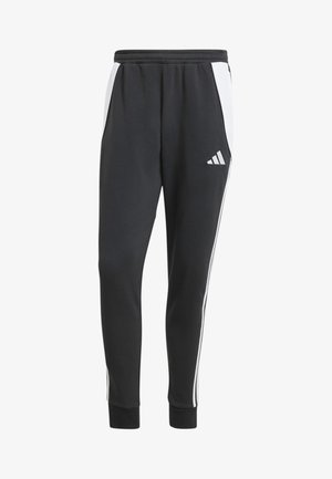 Black sweatpants with white side stripes, elastic waist, side pockets, and ribbed cuffs. Features logo on left thigh. Soft fabric texture.