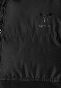 Svart vadderad jacka med ett glansigt, texturerat tyg och en diskret logotyp av en älg samt texten "FAT MOOSE" präglad på bröstområdet.