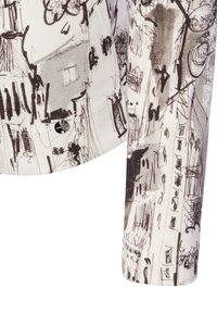 Witte stoffen shirt met een zwart schetsontwerp van gebouwen en bomen. Opmerkelijke details zijn een ronde zilveren knoop nabij de zoom.