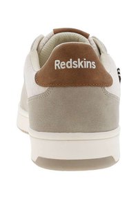 Sneaker con tomaia in camoscio grigio chiaro e beige, suola bianca e tallone in camoscio marrone. Presenta il logo "Redskins" in bianco sul tallone.
