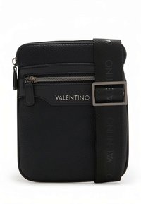 Mala preta de couro com superfície texturizada, compartimento com fecho de correr e alça ajustável com o nome da marca impresso em logotipo.