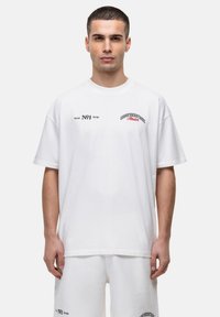 Witte katoen t-shirt met ronde hals, korte mouwen en geprinte tekst in zwart en rood. Losse pasvorm zonder zichtbare patronen.