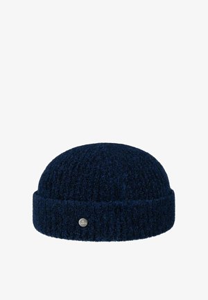 Dark navy blue knitted woolen beanie with folded brim and small metallic circular logo tag on the cuff.