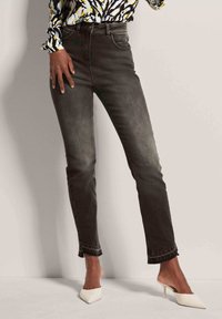 Donkergrijze jeans met een slim fit, met een lichte wasafwerking, een rafelige zoom en een standaard vijf-pocket ontwerp. Gekocht met witte spitse hakken.