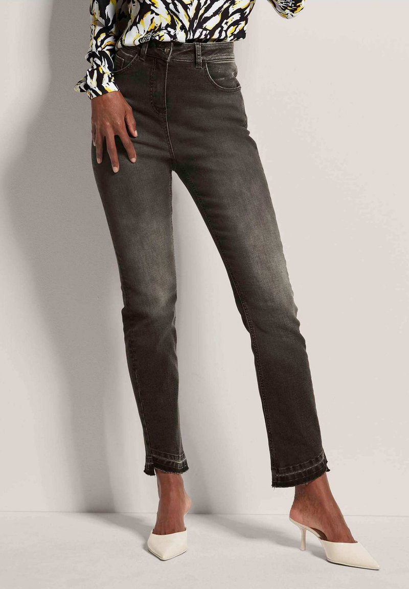 Donkergrijze jeans met een slim fit, met een lichte wasafwerking, een rafelige zoom en een standaard vijf-pocket ontwerp. Gekocht met witte spitse hakken.