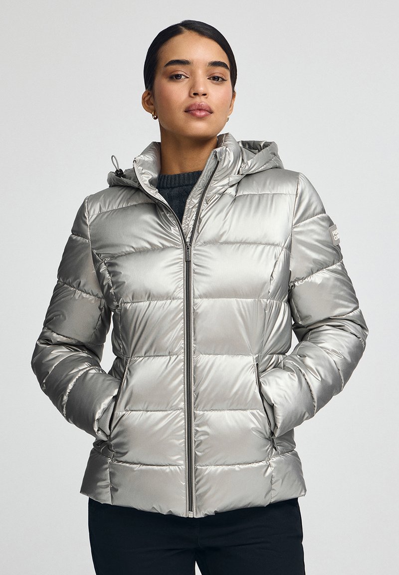Silverfärgad puffjacka med huva, utrustad med quiltade sektioner, en frontdragkedja och sidofickor. Slätt, glansigt tyg med en figursydd design.