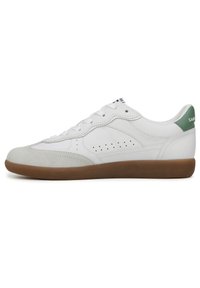 White leather sneaker with a smooth finish, light green heel accent, perforated sides, and a brown rubber sole.