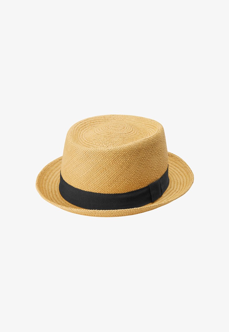 Olkihattu, jossa on pyöreä kruunu ja leveä lippa, luonnollinen beige väri, varustettuna mustalla nauhalla hatun alareunassa.