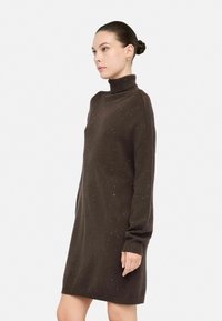 Bruine sweaterjurk, col, lange mouwen, met textuur en verspreide lichte accenten, knie-lengte, relaxte pasvorm, geribde manchetten en zoom.
