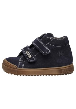 Scarpa alta in suede blu navy con due cinturini in velcro, cuciture leggere e suola in gomma. Suola brown testurizzata con caratteristiche di aderenza.
