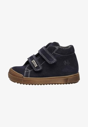 Scarpa alta in suede blu navy con due cinturini in velcro, cuciture leggere e suola in gomma. Suola brown testurizzata con caratteristiche di aderenza.