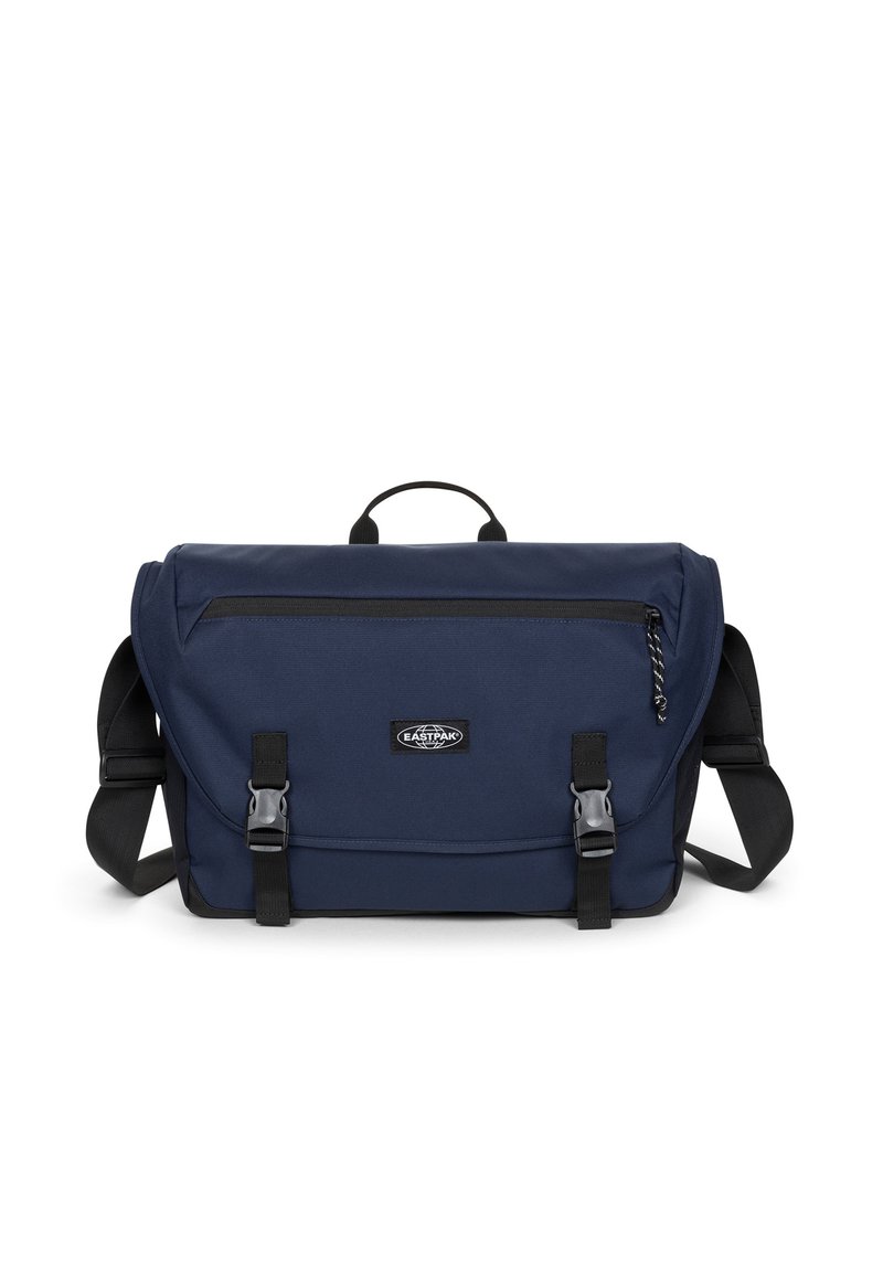 Borsa a tracolla Eastpak blu navy con tracolla regolabile nera, tasca con zip anteriore e due chiusure a fibbia nere sul risvolto.