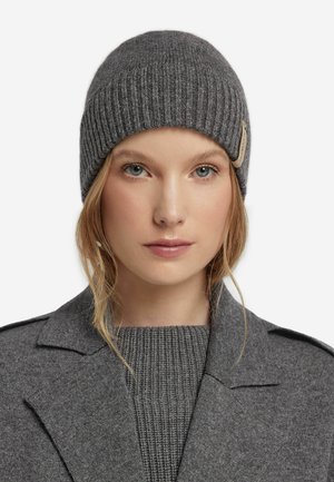 Grå strikket beanie med ribbet tekstur, der har et diskret logo-patch. Materialet ser blødt og varmt ud, velegnet til koldt vejr.