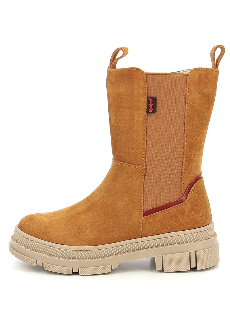 Botín de tobillo de ante marrón con interior texturizado, paneles laterales elásticos, tira para poner y una suela de goma beige gruesa con detalles de tracción.