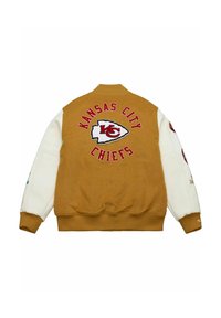 Kansas City Chiefs varsity jacket with tan body, white sleeves, and team logo centered on the back.