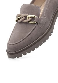 Mocassin en daim taupe avec semelle en caoutchouc épaisse et détail décoratif en chaîne beige et doré à l'avant.