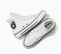 Zapatillas altas blancas con suela de goma, acentos negros y ojales de metal. Cuenta con un parche circular con un logo en el lateral.