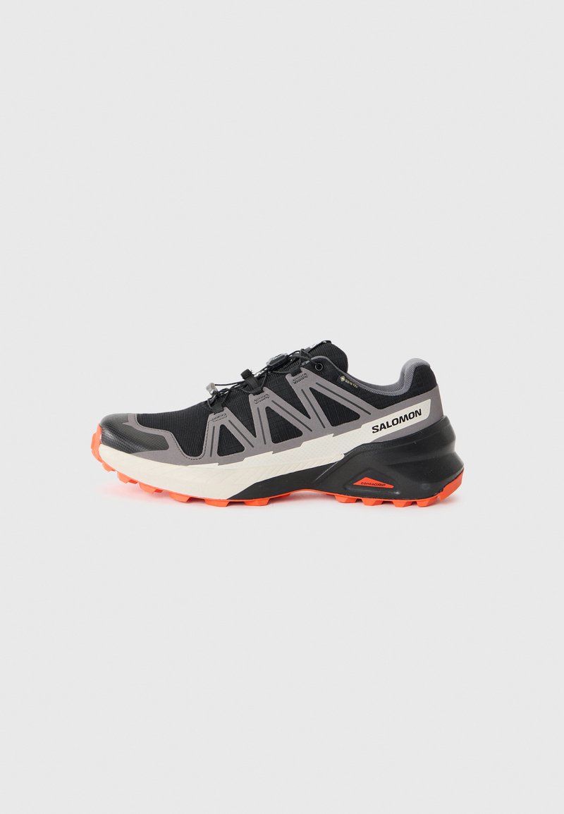 Black athletic shoe with a textured mesh upper, grey synthetic accents, and a rugged orange sole. Features a quick-lace system for easy adjustment.