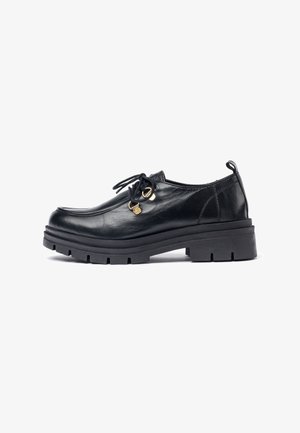 Zapato negro de piel con cordones, con punta redondeada, suela de goma negra gruesa y acentos de hardware dorado. Textura suave con un diseño minimalista.