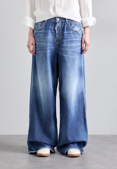 Jeans in denim blu a gamba larga con lavaggio chiaro, dotati di vita alta, tasche frontali e chiusura con bottone. Tessuto morbido, leggermente strappati.