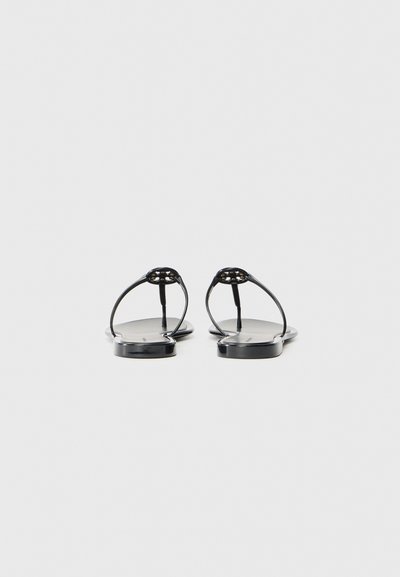 Svarte flate sandaler med tynne stropper og et minimalistisk design. Sålene er glatte og noe blanke, uten intrikate mønstre.