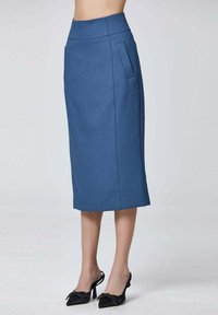 Jupe crayon bleue avec une taille ajustée, des poches latérales et une coupe à hauteur des genoux. Fabriquée dans un tissu lisse, elle présente des lignes épurées et un minimum de détails.